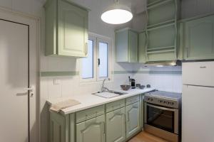 a kitchen with green cabinets and a sink at Casa em bairro típico de Aveiro in Aveiro