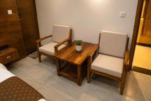 a room with a wooden table and two chairs at Hotel Kartikey Near Jio Centre in Sundarnagar +21 photos