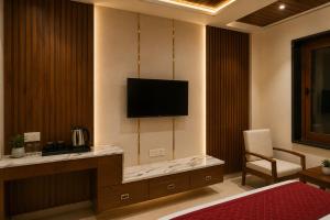 a hotel room with a television on a wall at Hotel Kartikey Near Jio Centre in Sundarnagar