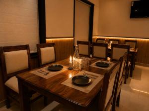 a dining room with a wooden table and chairs at Hotel Kartikey Near Jio Centre in Sundarnagar