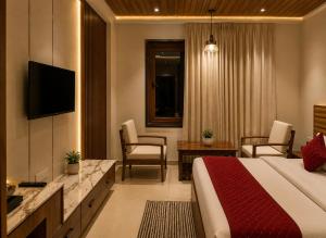 a hotel room with a bed and a television at Hotel Kartikey Near Jio Centre in Sundarnagar