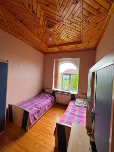 two beds in a room with a window at Palm Garden House Lankaran in Lankaran