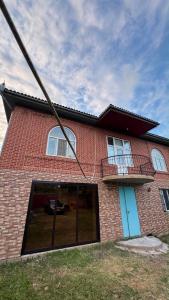 a red brick house with a large window at Palm Garden House Lankaran in Lankaran +10 photos