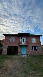 a red brick house with a blue door at Palm Garden House Lankaran in Lankaran