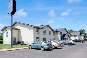 a parking lot with cars parked in front of a building at Coldwater Inn & Suites near I 69 in Coldwater