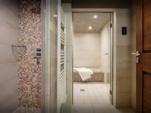 a bathroom with a shower and a bed in a room at Pralor Le Peille - OVO Network in Manigod