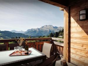 a table on a balcony with a view of mountains at Pralor Le Peille - OVO Network in Manigod