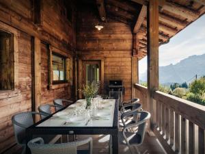 a dining room with a table and chairs on a balcony at Pralor Le Peille - OVO Network in Manigod