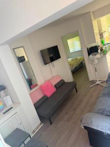 a living room with a couch and a flat screen tv at Heathrow One Bed Family Flat in South Ruislip Station