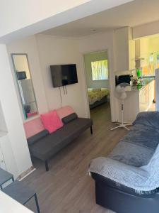 a living room with two beds and a tv at Heathrow One Bed Family Flat in South Ruislip Station