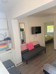a living room with a couch and a flat screen tv at Heathrow One Bed Family Flat in South Ruislip Station