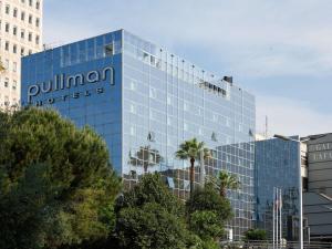 a blue glass building with a sign on it at Pullman La Pléiade Montpellier Centre in Montpellier