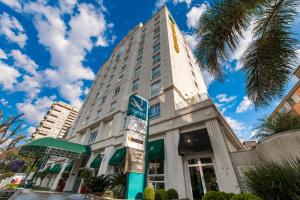 a tall building with a sign in front of it at Quality Hotel Curitiba in Curitiba