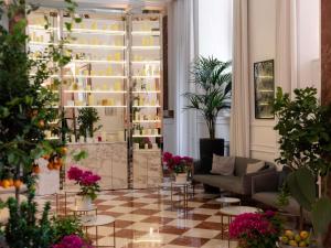 ein Wohnzimmer mit einer Couch und einigen Pflanzen in der Unterkunft Sofitel Roma Villa Borghese in Rom