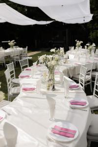 a group of white tables with pink and white napkins at Villa Restart in Bijeljina +96 photos