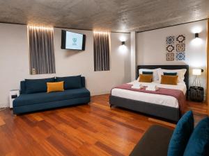 a bedroom with a large bed and a couch at Fervença Apartments in Vila Nova de Gaia