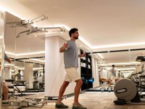 Ein Mann steht in einem Fitnessstudio und hält einen Wii-Controller in der Unterkunft Hotel Rotary Geneva - MGallery in Genf