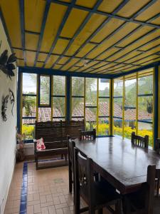 a dining room with a table and chairs and windows at El Rancho de Salento in Salento