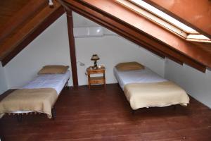 a attic room with two beds and a table at Nonna Sofia in Krikellos