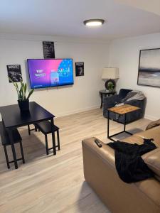 a living room with a couch and a table and a tv at Daphne's Tropical Oasis Boutique Hostel in Hallandale Beach