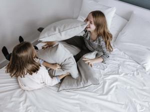 two girls laying on a bed with pillows at Mercure Hotel München Süd Messe in Munich +72 photos