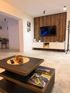 a living room with a table and a tv at HARMONY STONE ViLLA in Ovčar Banja