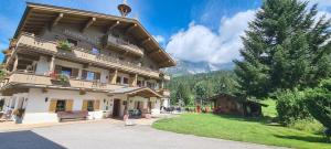 a large building with a bench in front of it at Landhaus Wildschwendt in Ellmau