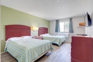 a hotel room with two beds and a window at Coldwater Inn & Suites near I 69 in Coldwater