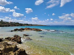 a beach with rocks and the ocean on a sunny day at Kalamea Apartment Kalathas in Kalathas