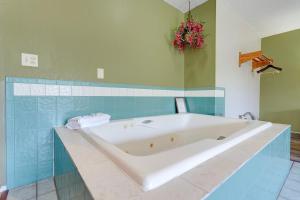 a bath tub in a bathroom with blue tiles at Coldwater Inn & Suites near I 69 in Coldwater +45 photos