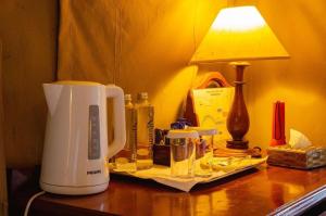 a coffee maker sitting on a table with a lamp at Sweetwaters Serena Camp in Nanyuki