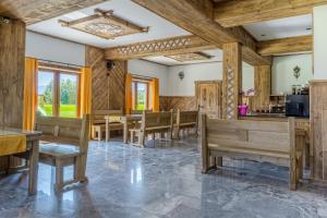 a dining room with wooden walls and tables and benches at "Podhalański Gościniec" -250 m Gorący Potok ,Termy Szaflary in Szaflary