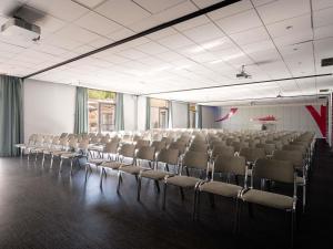 an empty room with chairs and a table in it at Mercure Bordeaux Aéroport in Mérignac +101 photos