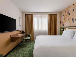 a hotel room with a bed and a flat screen tv at Hôtel Mercure Lyon Centre Lumière in Lyon