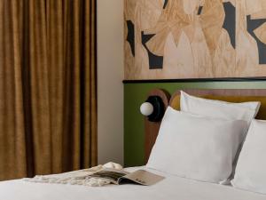 a bedroom with a bed with a book on it at Hôtel Mercure Lyon Centre Lumière in Lyon