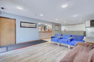 a waiting room with blue chairs and a table at Coldwater Inn & Suites near I 69 in Coldwater