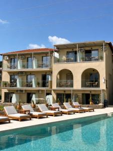 a hotel with lounge chairs and a swimming pool at Astoria Hotel in Troulos