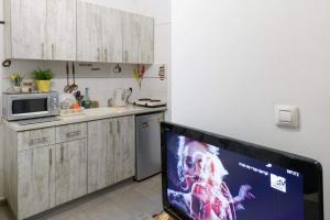 a kitchen with a tv in a small kitchen at דירת סטודיו ליד הים ברחוב בוגרשוב המבוקש in Tel Aviv +1 photo