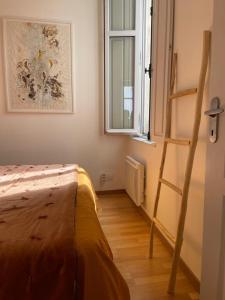 a bedroom with a ladder next to a window at Bright apartment - old renovated building in Nantes