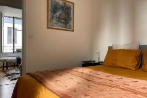 a bedroom with a bed and a picture on the wall at Bright apartment - old renovated building in Nantes