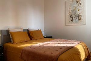 a bedroom with a large bed with yellow sheets at Bright apartment - old renovated building in Nantes