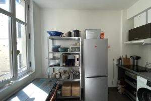 a white refrigerator in a kitchen with a window at Bright apartment - old renovated building in Nantes +6 photos