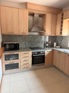 an empty kitchen with wooden cabinets and appliances at Vila Rio DOuro in Ferragudo +20 photos