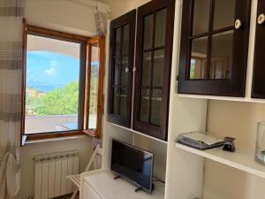 a living room with a tv and a window at Villa Marina piano terra in Rio Marina