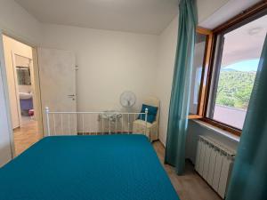 a bedroom with a blue bed and a window at Villa Marina piano terra in Rio Marina