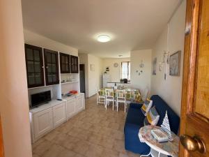 a living room with a blue couch and a kitchen at Villa Marina piano terra in Rio Marina
