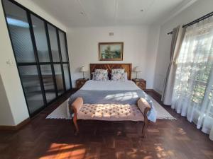 a bedroom with a large bed with a large window at Ambiance Guesthouse in Pretoria