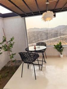 a table and chairs on a balcony with a view at شاليهات سكوْن in Al Baha