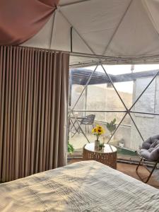 a bedroom with a bed and a large window at شاليهات سكوْن in Al Baha