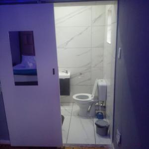 a white bathroom with a toilet and a sink at Rs Air in Gqeberha